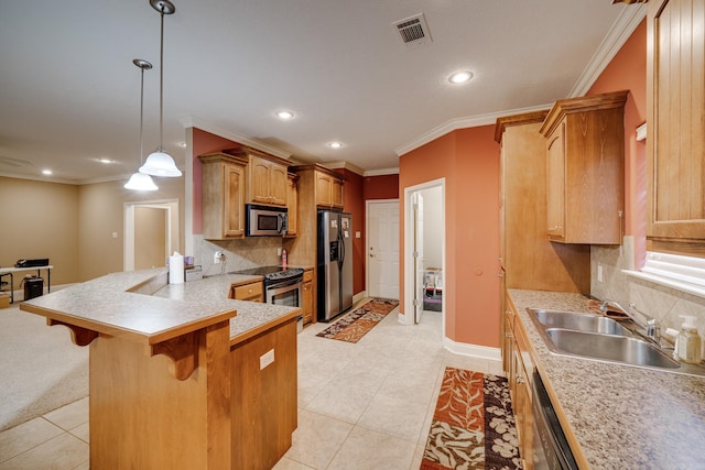 kitchen with tasteful backsplash, sink, a kitchen bar, appliances with stainless steel finishes, and decorative light fixtures