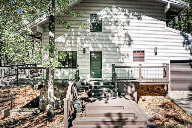 rear view of house featuring a wooden deck