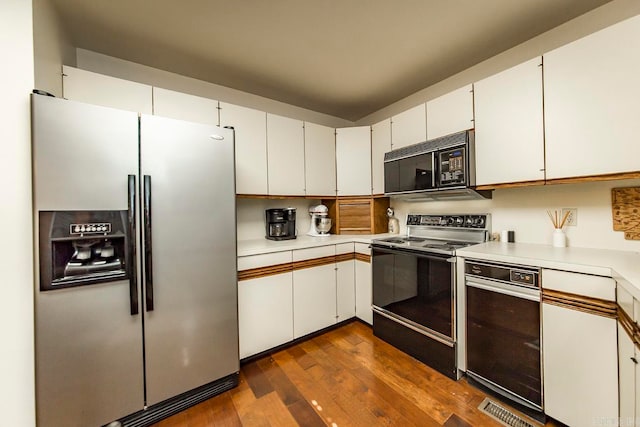 kitchen featuring electric stove, white cabinets, stainless steel fridge, and dark hardwood / wood-style floors