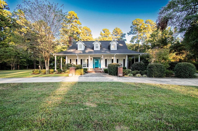 cape cod home featuring a porch and a front lawn