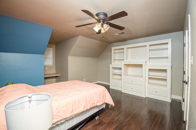 bedroom with dark wood-style floors, visible vents, lofted ceiling, and a textured ceiling