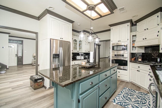 kitchen with ornamental molding, visible vents, white cabinets, and appliances with stainless steel finishes