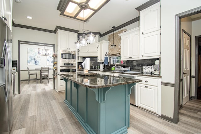 kitchen with decorative backsplash, white cabinets, crown molding, stainless steel appliances, and a breakfast bar area