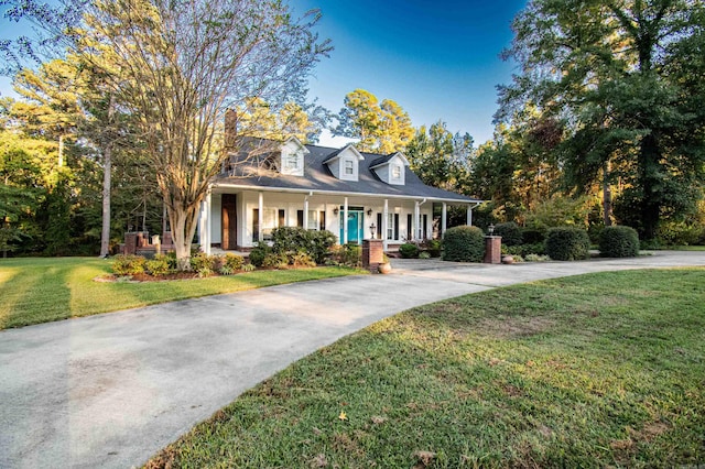 new england style home with a porch and a front yard