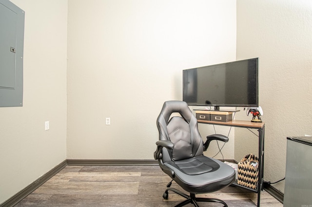 home office with electric panel, baseboards, and wood finished floors