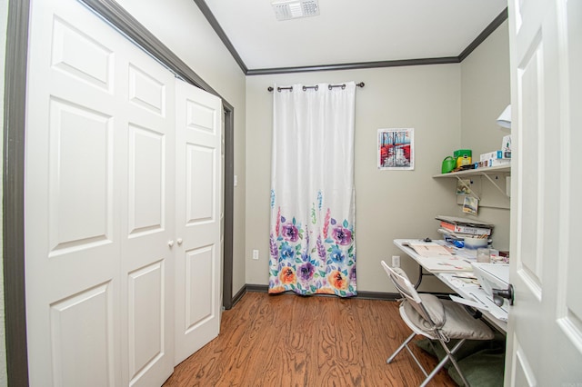 office with baseboards, ornamental molding, visible vents, and wood finished floors