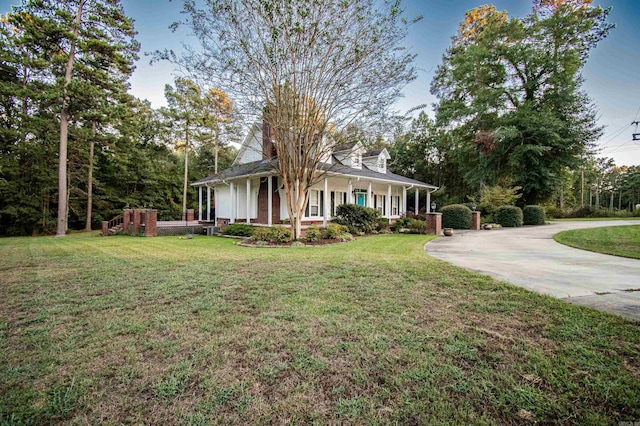 view of front of property with driveway, a front lawn, and a porch