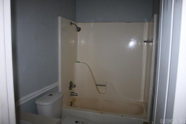 bathroom featuring washtub / shower combination and toilet