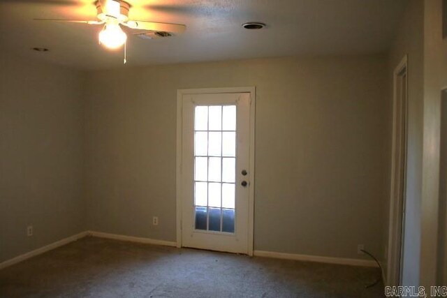 doorway with ceiling fan and carpet flooring