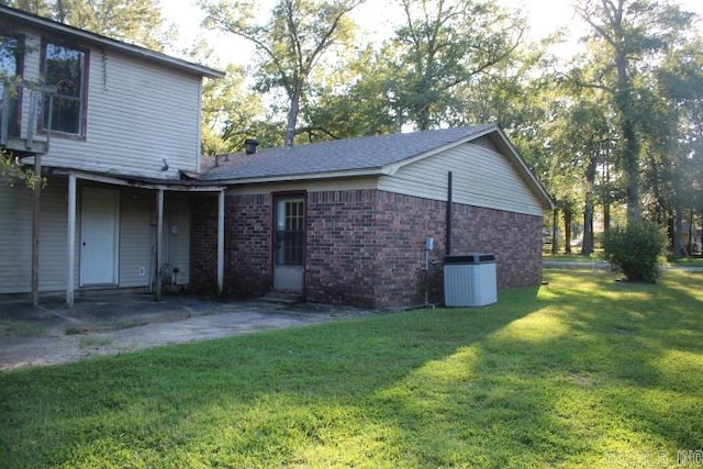 back of house featuring cooling unit and a lawn