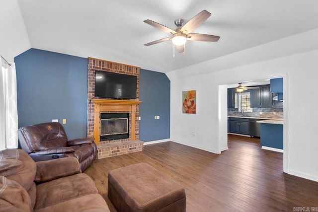 living room featuring lofted ceiling, ceiling fan, a fireplace, and dark hardwood / wood-style flooring