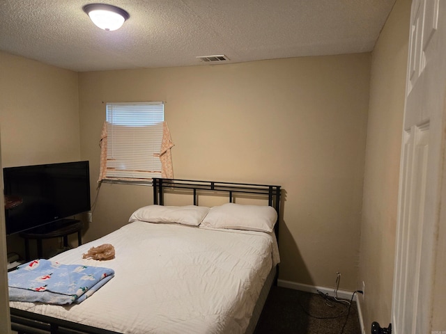 bedroom featuring a textured ceiling and carpet flooring