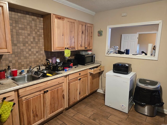 kitchen featuring decorative backsplash, a textured ceiling, refrigerator, and sink