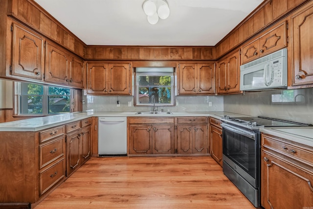 kitchen featuring light hardwood / wood-style floors, white appliances, sink, and plenty of natural light