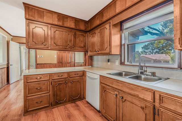 kitchen with dishwasher, light hardwood / wood-style floors, sink, and kitchen peninsula