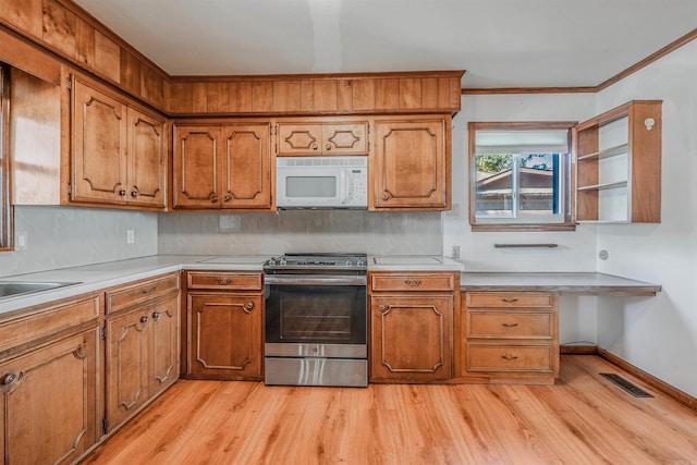 kitchen featuring light hardwood / wood-style floors, tasteful backsplash, stainless steel range oven, crown molding, and sink