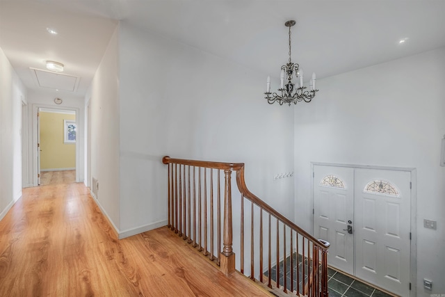 corridor with hardwood / wood-style floors and a notable chandelier