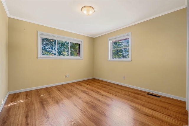 empty room featuring light hardwood / wood-style flooring and crown molding