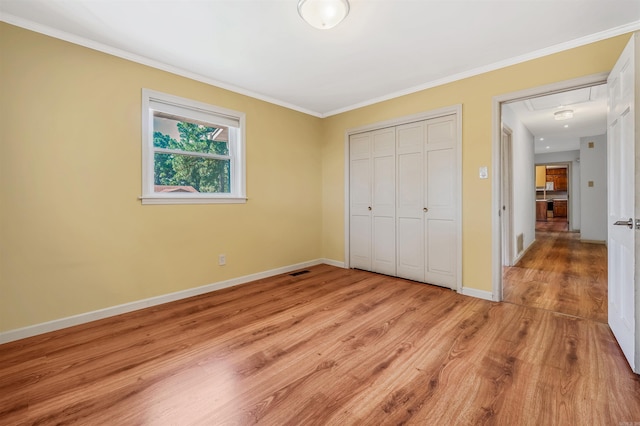 unfurnished bedroom featuring ornamental molding, a closet, and light hardwood / wood-style floors