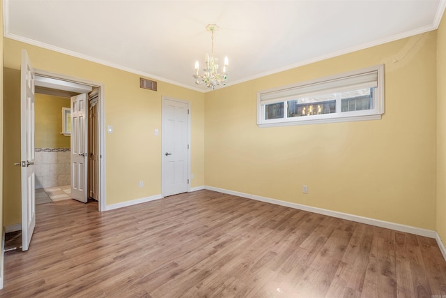 unfurnished bedroom featuring tile walls, crown molding, light hardwood / wood-style floors, and a chandelier