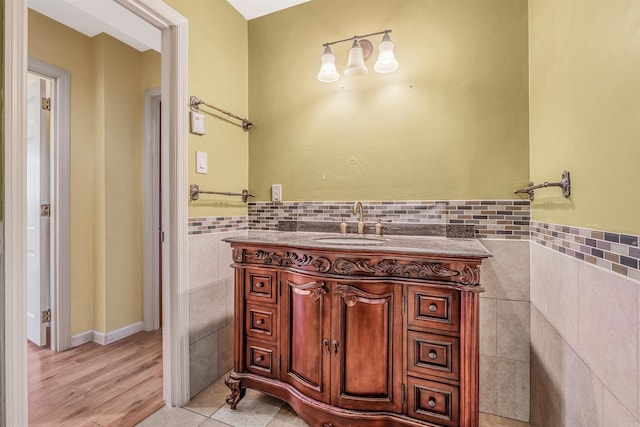 bathroom featuring tile walls, vanity, and hardwood / wood-style floors