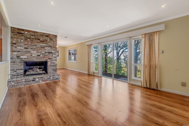 unfurnished living room featuring crown molding, a fireplace, and light hardwood / wood-style flooring