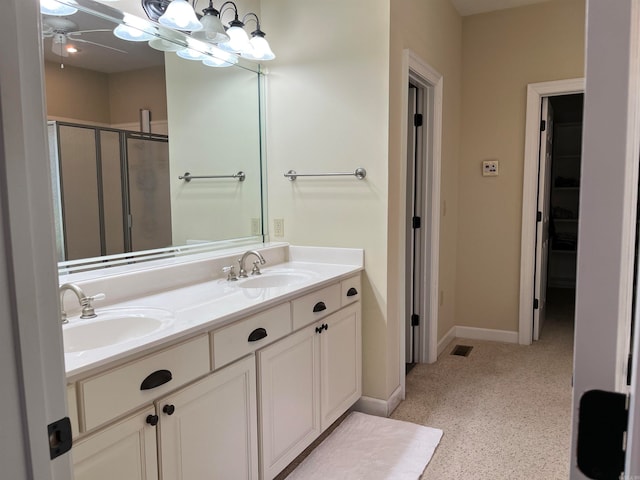 bathroom with a shower with door and vanity