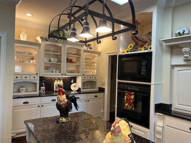 kitchen with ornamental molding, white cabinets, black appliances, and dark stone countertops