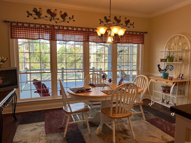 dining area with crown molding, an inviting chandelier, and plenty of natural light