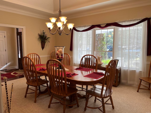 dining space with a chandelier, light colored carpet, and crown molding