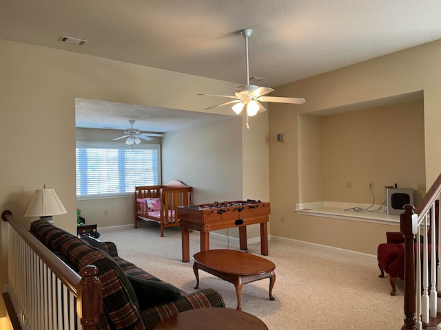 living room featuring a textured ceiling, carpet, and ceiling fan