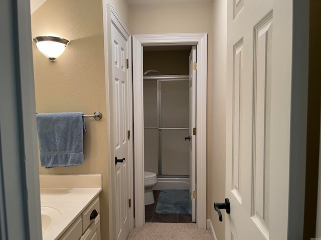 bathroom featuring vanity, tile patterned floors, an enclosed shower, and toilet