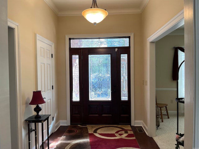 carpeted foyer featuring ornamental molding