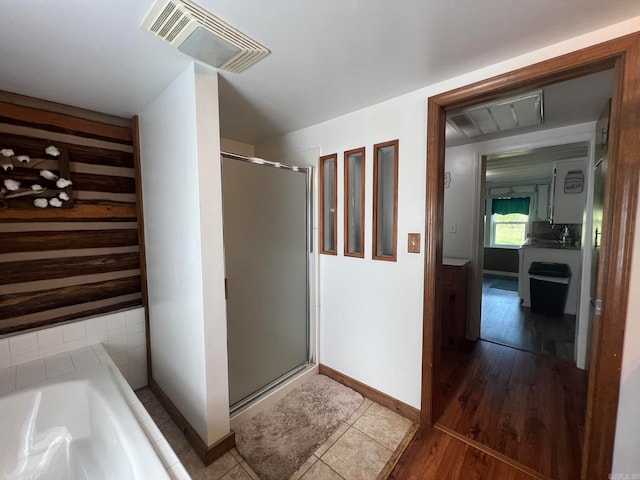 bathroom with shower with separate bathtub and hardwood / wood-style floors