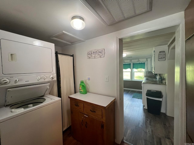 laundry room featuring stacked washer / dryer and dark hardwood / wood-style flooring