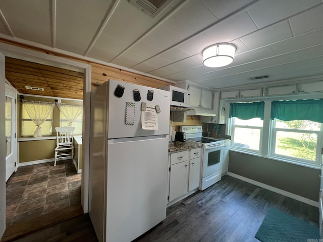 kitchen with white cabinets, dark stone counters, dark hardwood / wood-style floors, and white appliances