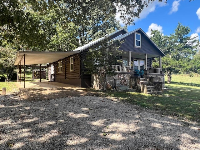 view of front of house featuring a front lawn, covered porch, and a carport