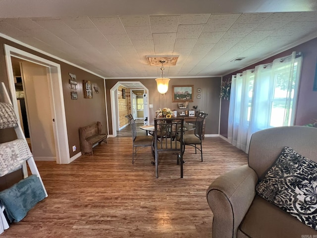 dining area featuring crown molding and hardwood / wood-style floors