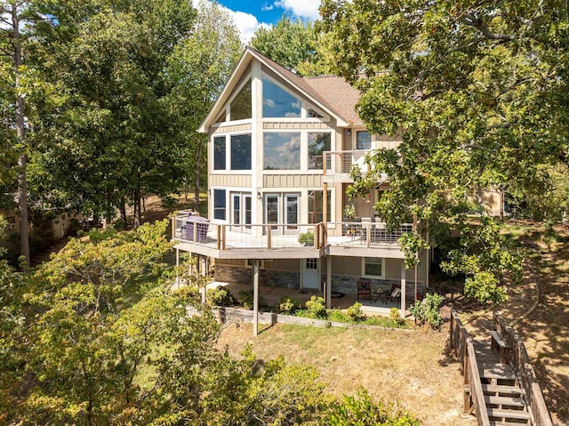 rear view of house featuring a deck and a patio area