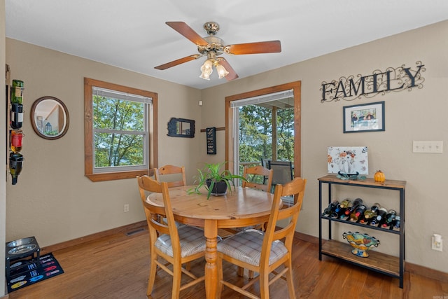 dining room with light wood-type flooring, ceiling fan, and a wealth of natural light