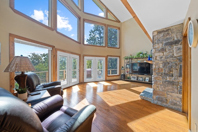 living room with light wood-type flooring, french doors, and high vaulted ceiling