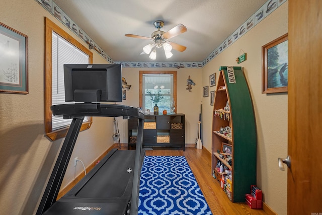 exercise room with wood-type flooring and ceiling fan