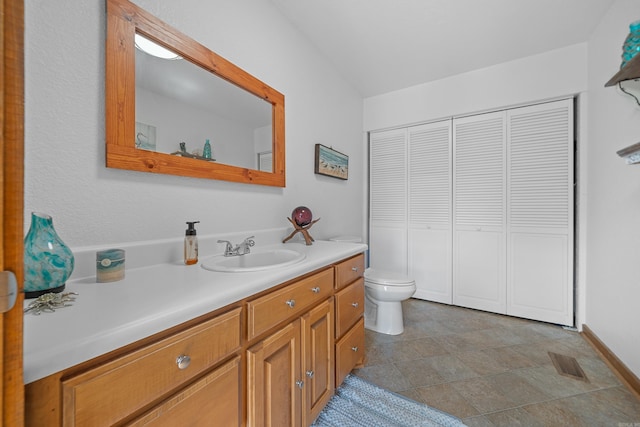 bathroom featuring vanity, tile patterned flooring, and toilet