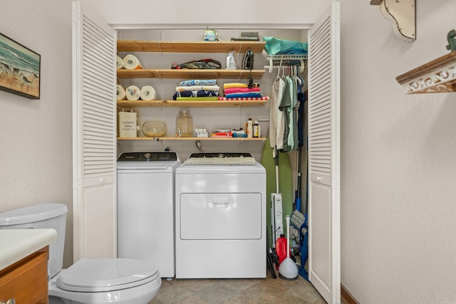 laundry area featuring light tile patterned floors and washer and dryer