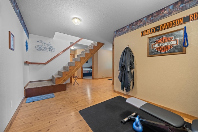 workout room featuring a textured ceiling and hardwood / wood-style floors