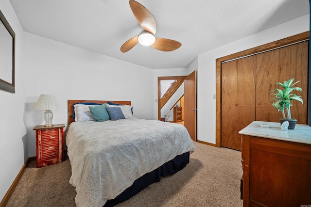 carpeted bedroom with ceiling fan and a closet