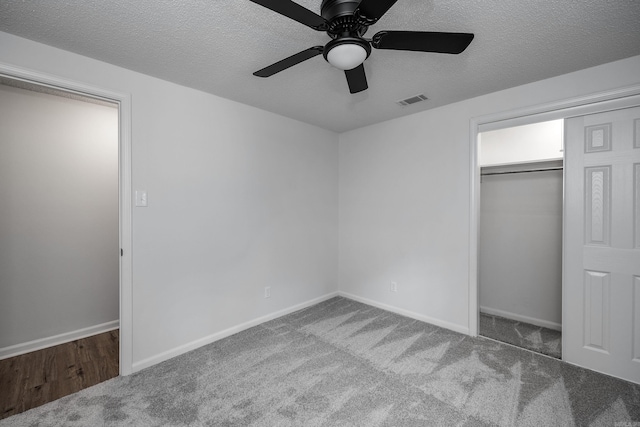 unfurnished bedroom with a textured ceiling, carpet, ceiling fan, and a closet