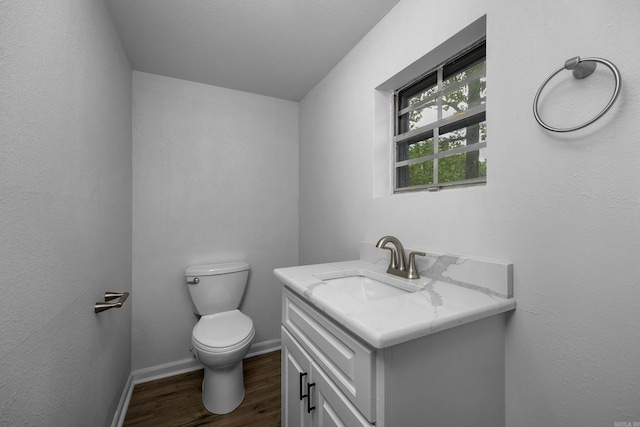 bathroom with hardwood / wood-style floors, vanity, and toilet