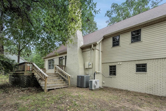 back of property featuring central AC, a deck, and ac unit