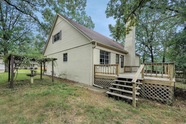 rear view of house with a lawn and a deck